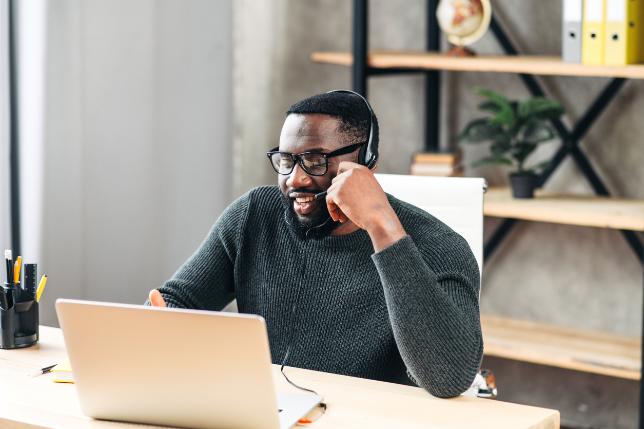 man-wearing-headset-using-laptop